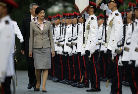 Thai PM Yingluck inspects an honour guard with her Singaporean ...